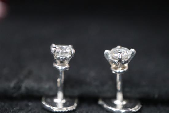 A pair of Cartier platinum set solitaire diamond ear studs, with Cartier box.